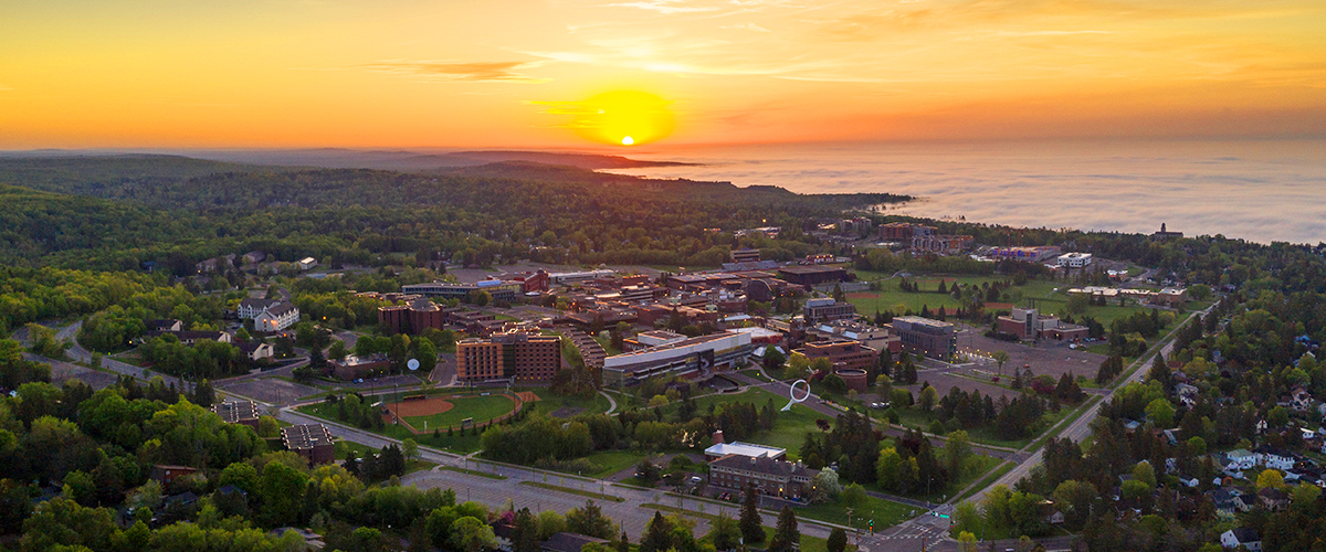 Aerial photo of campus on down to Lake Superior during sunrise