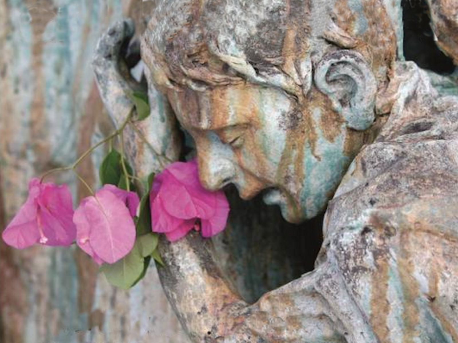 statue of boy holding pink flowers