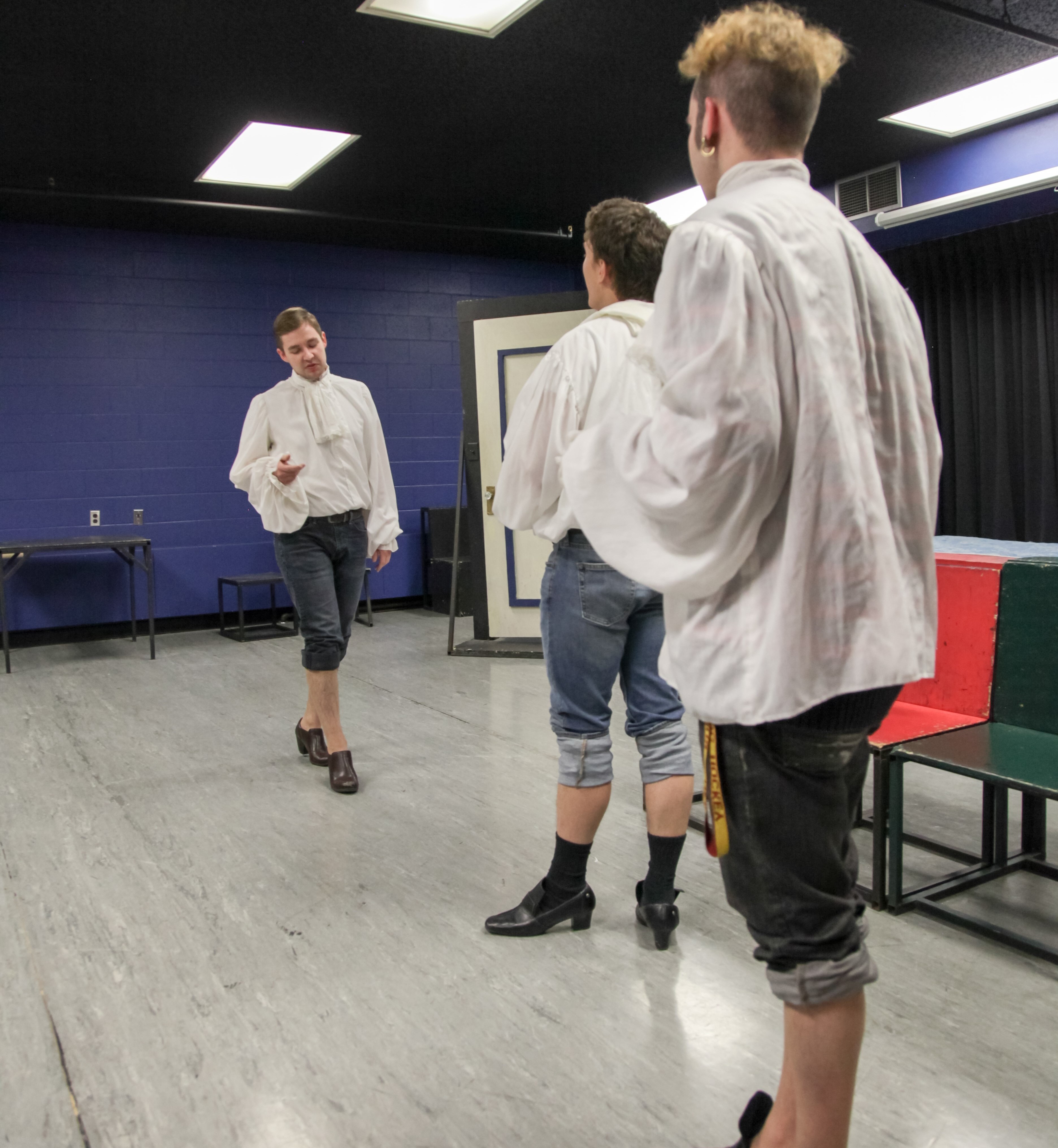 Student actors in period style shirts and shoes in class