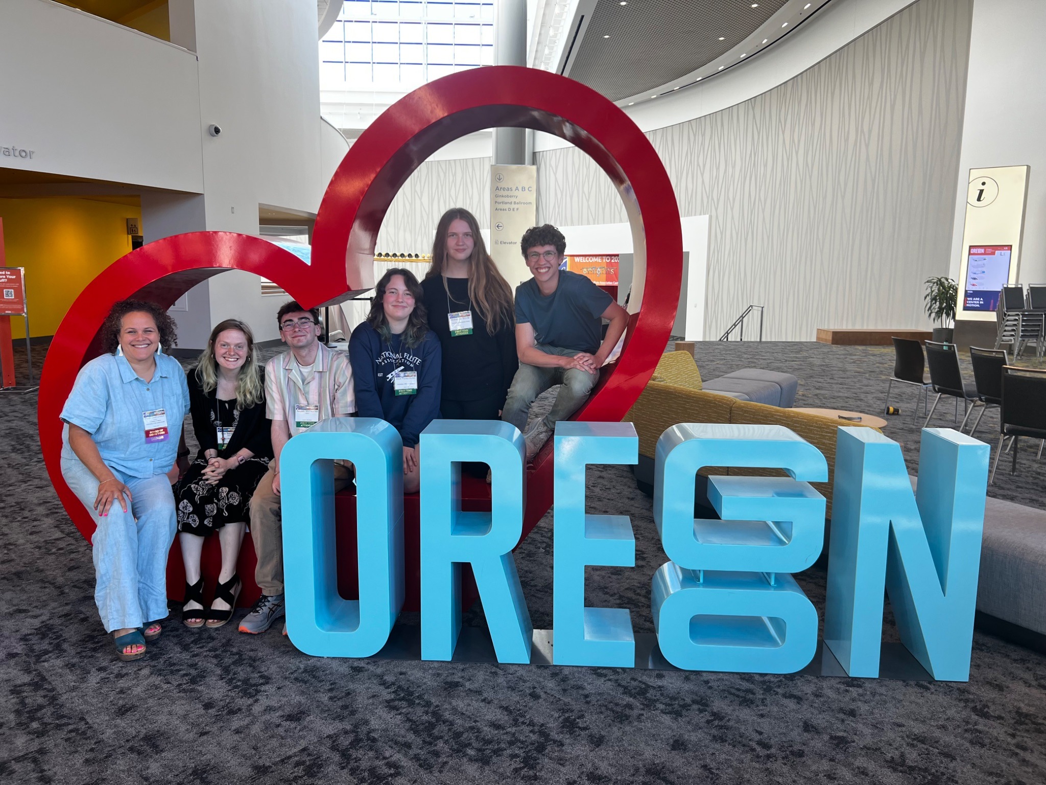 Flute studio students and professor pose around a cool statue of oregon