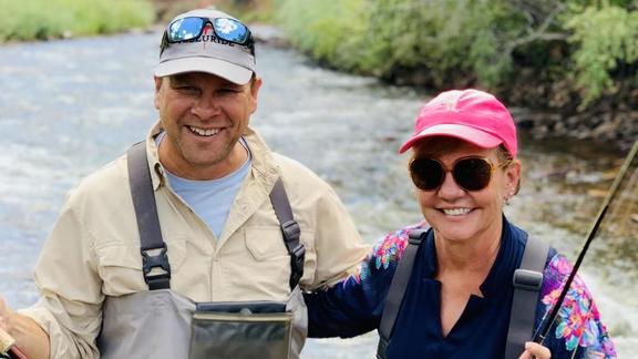 Jay and JL posing while fishing in a river