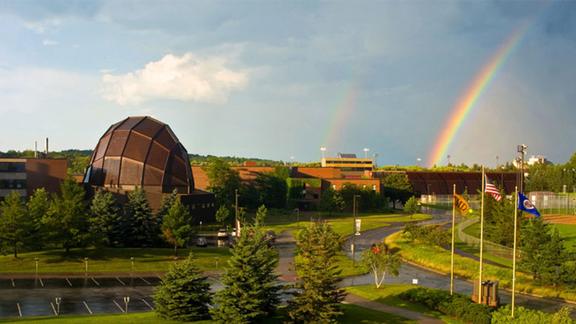 Aerial shot of UMD Campus featuring Weber Music Hall and a rainbow in the sky
