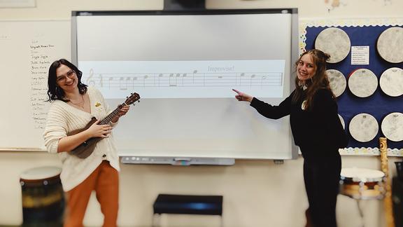 two music education students in front of the classroom