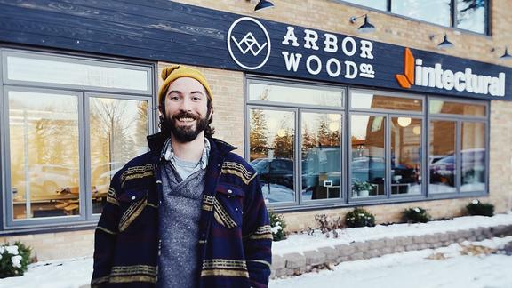 Maxwell McGruder standing in front of Arbor Wood Co storefront
