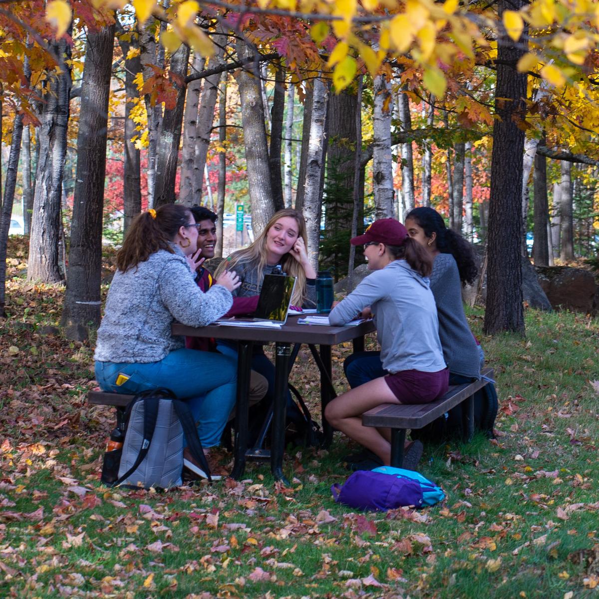 Students sitting outside at a table.