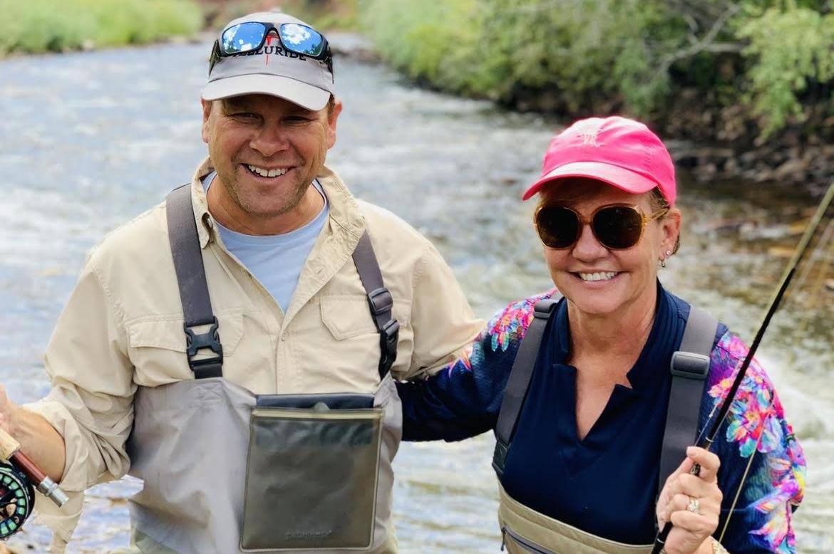 Jay and JL posing while fishing in a river