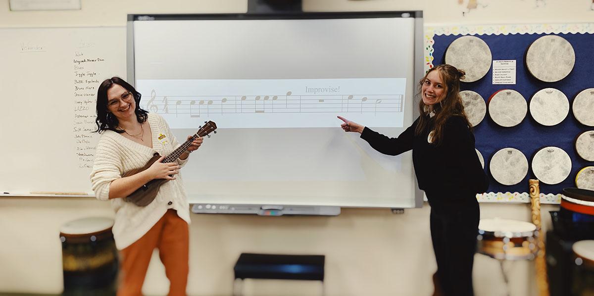 two music education students in front of the classroom