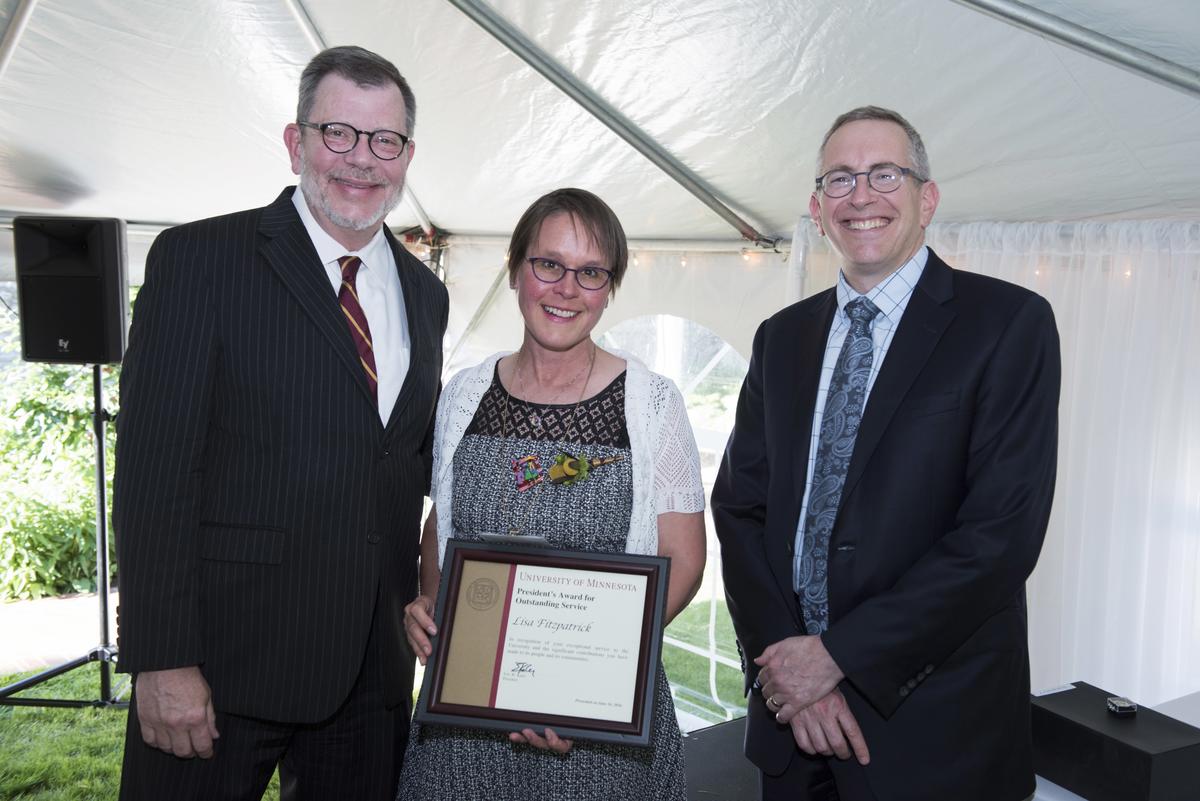 Lisa Fitzpatrick posing with her award, U of M President Eric Kaler, and Professor William Tolman