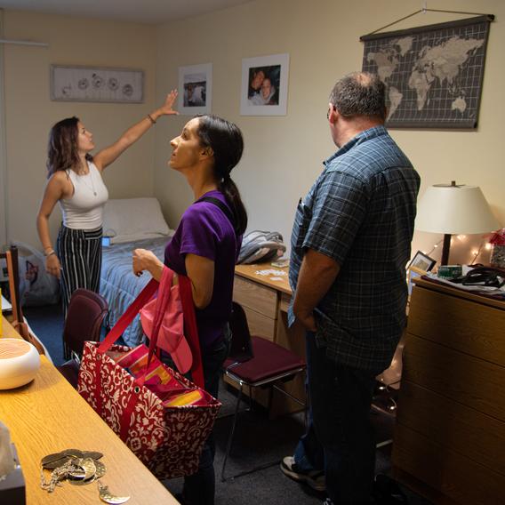 Student moving into dorm room with the help of her parents